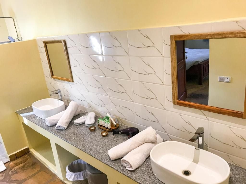 A bathroom with two sinks, a mirror, and a towel rack.