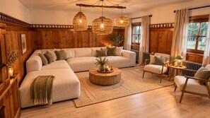 A cozy living room with a sectional sofa, a round coffee table, and wooden walls.