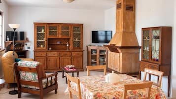 Un salon traditionnel avec des meubles en bois, un téléviseur et une cheminée.