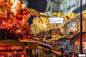 Eine Straße, geschmückt mit Luftballons, und ein Schild mit der Aufschrift 'RUE DES BULLES'.