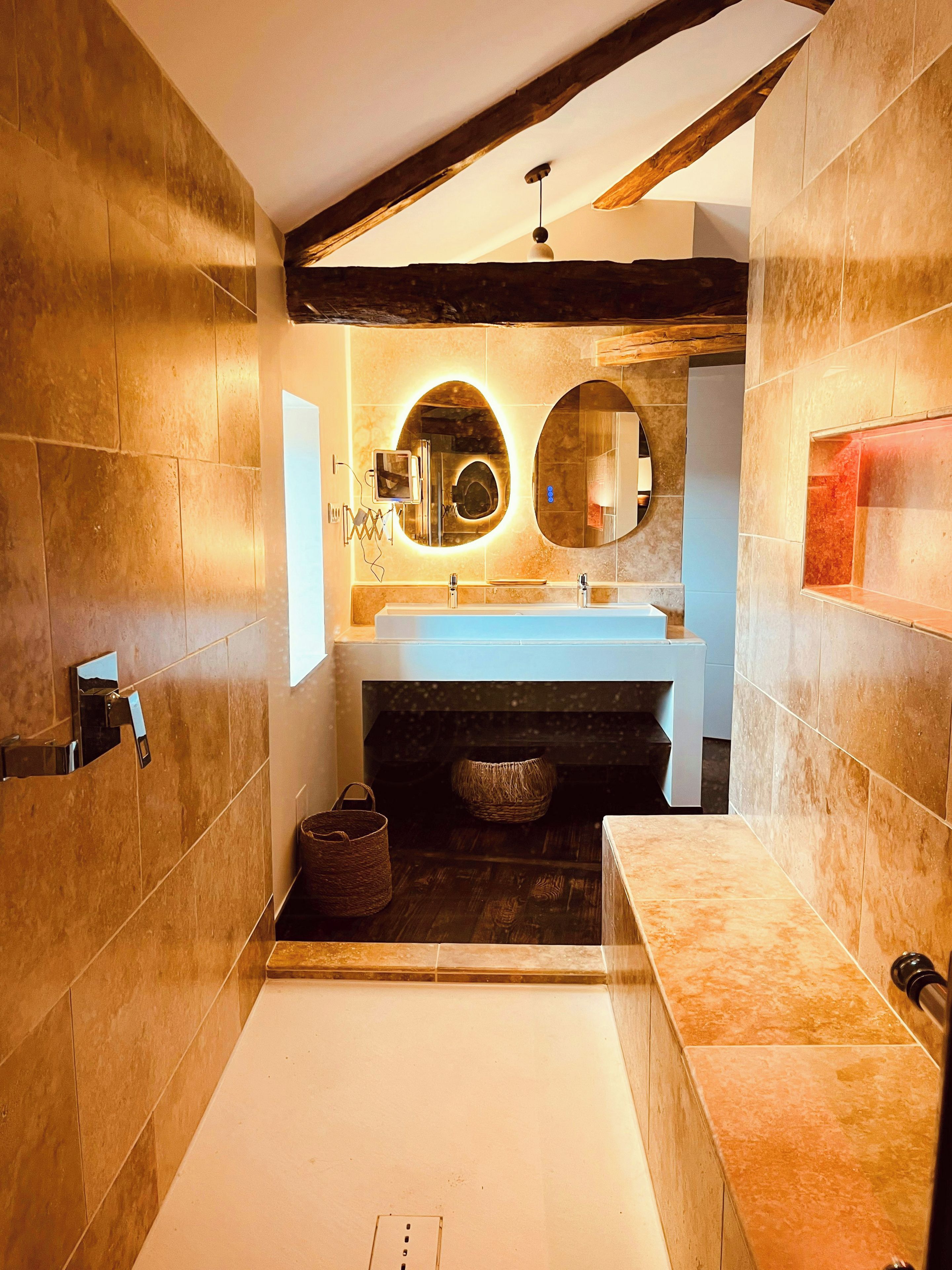 A modern bathroom with a large bathtub, a sink, and a mirror.