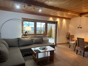 Un salon confortable avec un canapé, une table basse et un coin repas comprenant des chaises et une table.