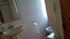 Un baño con lavamanos, inodoro y espejo.
