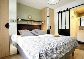 A bedroom with a bed, bedside lamps, a nightstand, and a wardrobe. - New Listing (Goult)