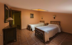 A hotel room with two beds, a nightstand, a lamp, a mirror, and a painting on the wall. - Country House 'Casa Rural Neveritas' with Private Terrace and Wi-Fi (Piedrahíta)