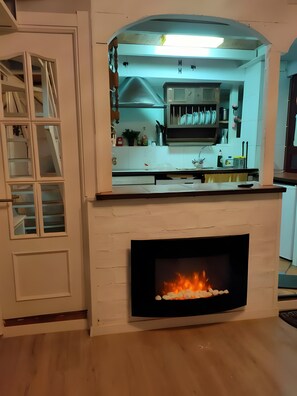 A kitchen with a fireplace, a built-in oven, and a window above the counter. - Country House 'Casa Rural Neveritas' with Private Terrace and Wi-Fi (Piedrahíta)