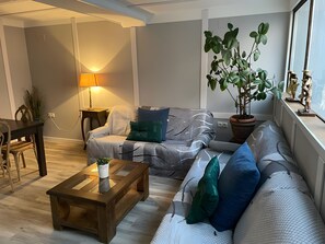 A living room with a sofa, a coffee table, a lamp, and a potted plant. - Country House 'Casa Rural Neveritas' with Private Terrace and Wi-Fi (Piedrahíta)
