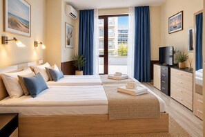 A hotel room with two beds, a TV, a desk, and a balcony with curtains. - Aparthotel Izvora Beachfront  (Golden sands)