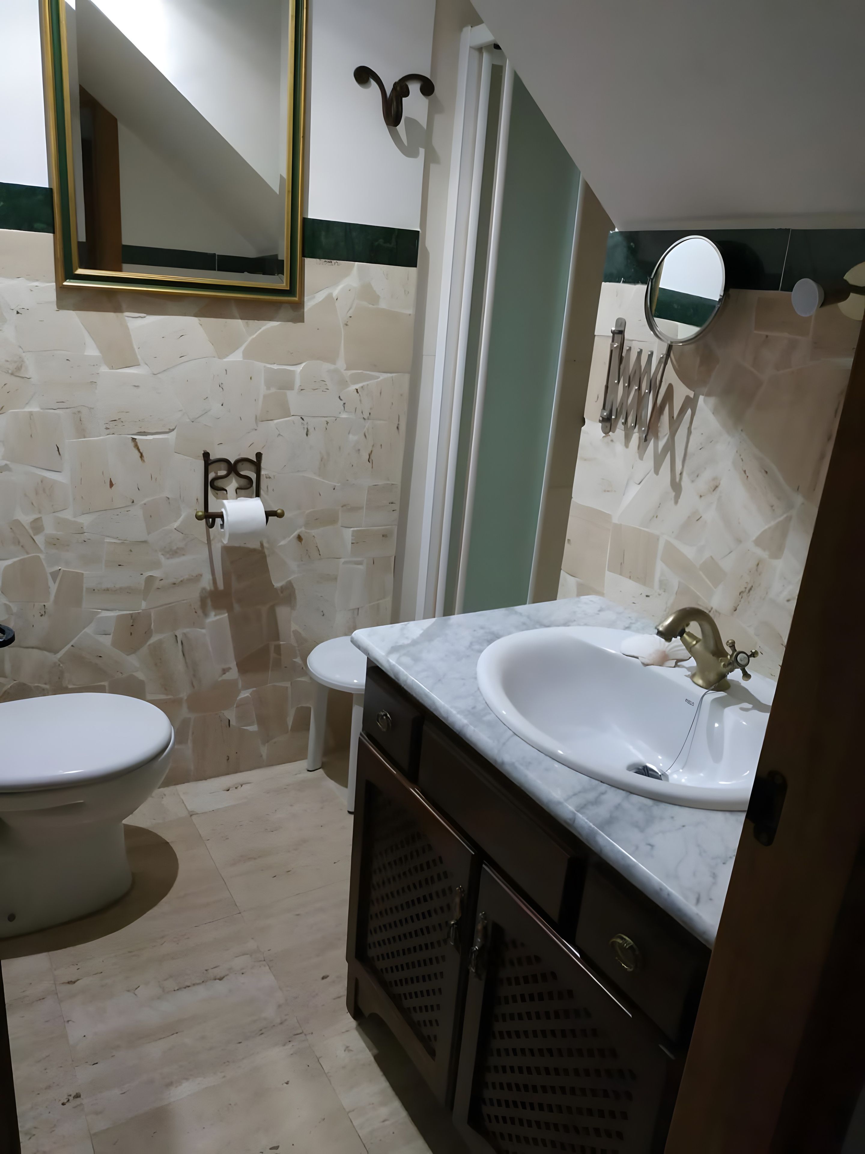 A bathroom with a toilet, a sink with a mirror, and a towel rack.