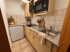 A compact kitchen with a built-in microwave, a sink, and a small refrigerator. - Historic Studio for up to 4 people (Ochsenfurt)