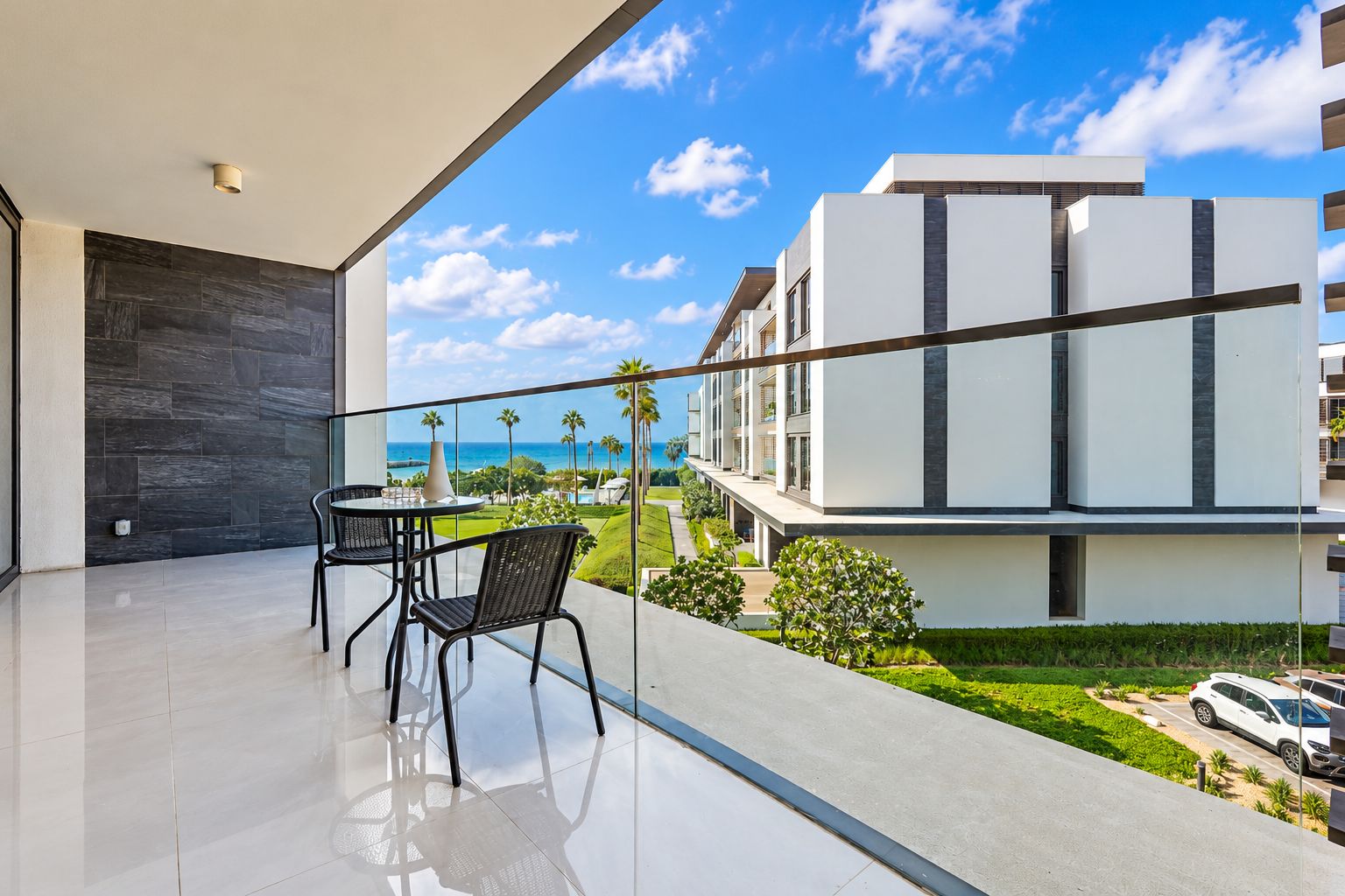 A balcony with a view of a modern building and the ocean.