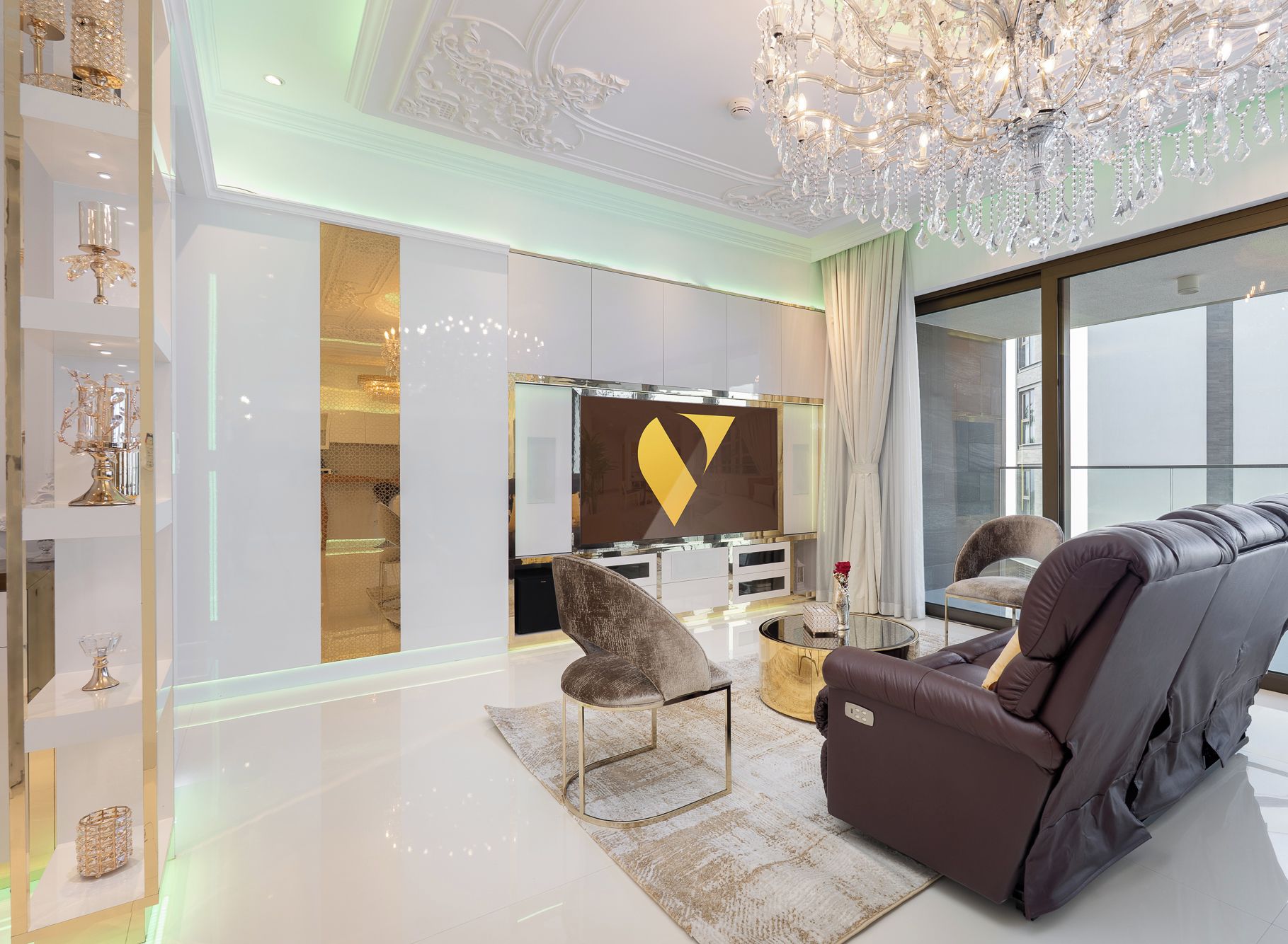 A modern living room with a large sofa, a chair, a coffee table, and a decorative chandelier.