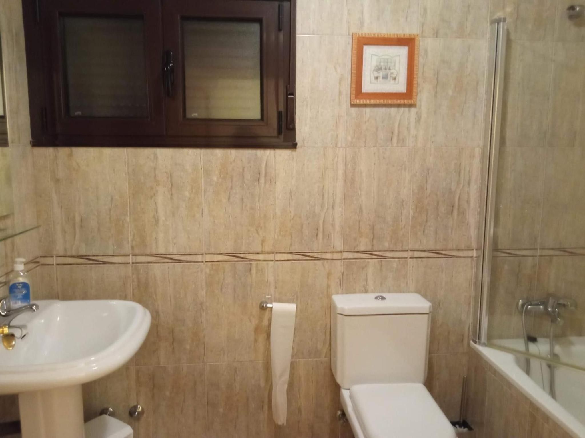 Un baño con lavamanos, inodoro y ducha.