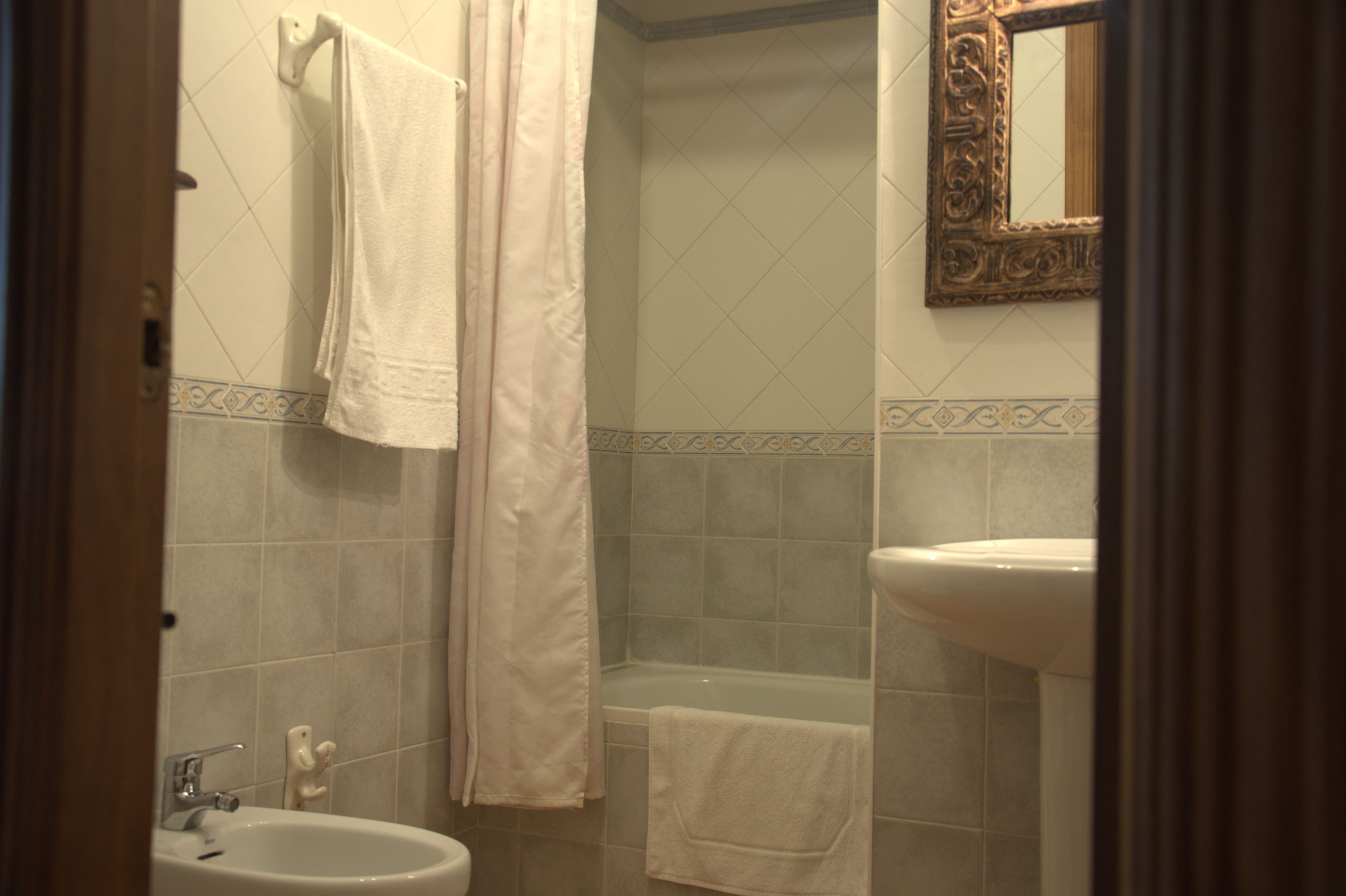 Une salle de bain équipée d’un lavabo, d’une baignoire et d’un rideau de douche.