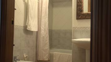Une salle de bain équipée d’un lavabo, d’une baignoire et d’un rideau de douche.
