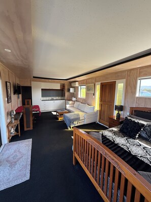 A compact living space with a kitchenette, a sofa, a bed, and a small dining area. - A peaceful harbour-side retreat in the beautiful Eastern Bay of Plenty (Wainui)
