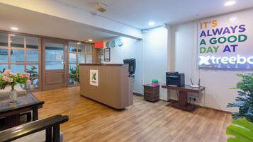 A reception area with a wooden desk, a computer, and a sign that reads 'IT'S ALWAYS A GOOD DAY AT Xtreebo.'