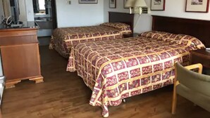 Habitación de hotel con dos camas, un aparador de madera, un escritorio y una silla.
