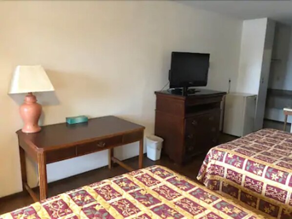 A hotel room with two beds, a desk, a television, and a dresser. - Kings Motor Inn (Fife)