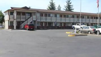 A multi-story building with a parking lot in front.