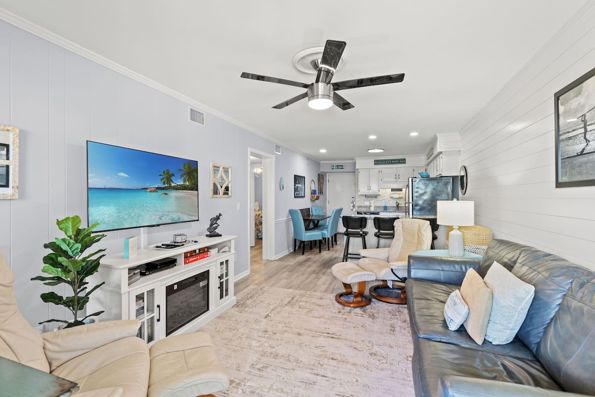 Condo Deluxe, 2 habitaciones, balcón, vista parcial al océano (106E) | Área de sala de estar | Televisión