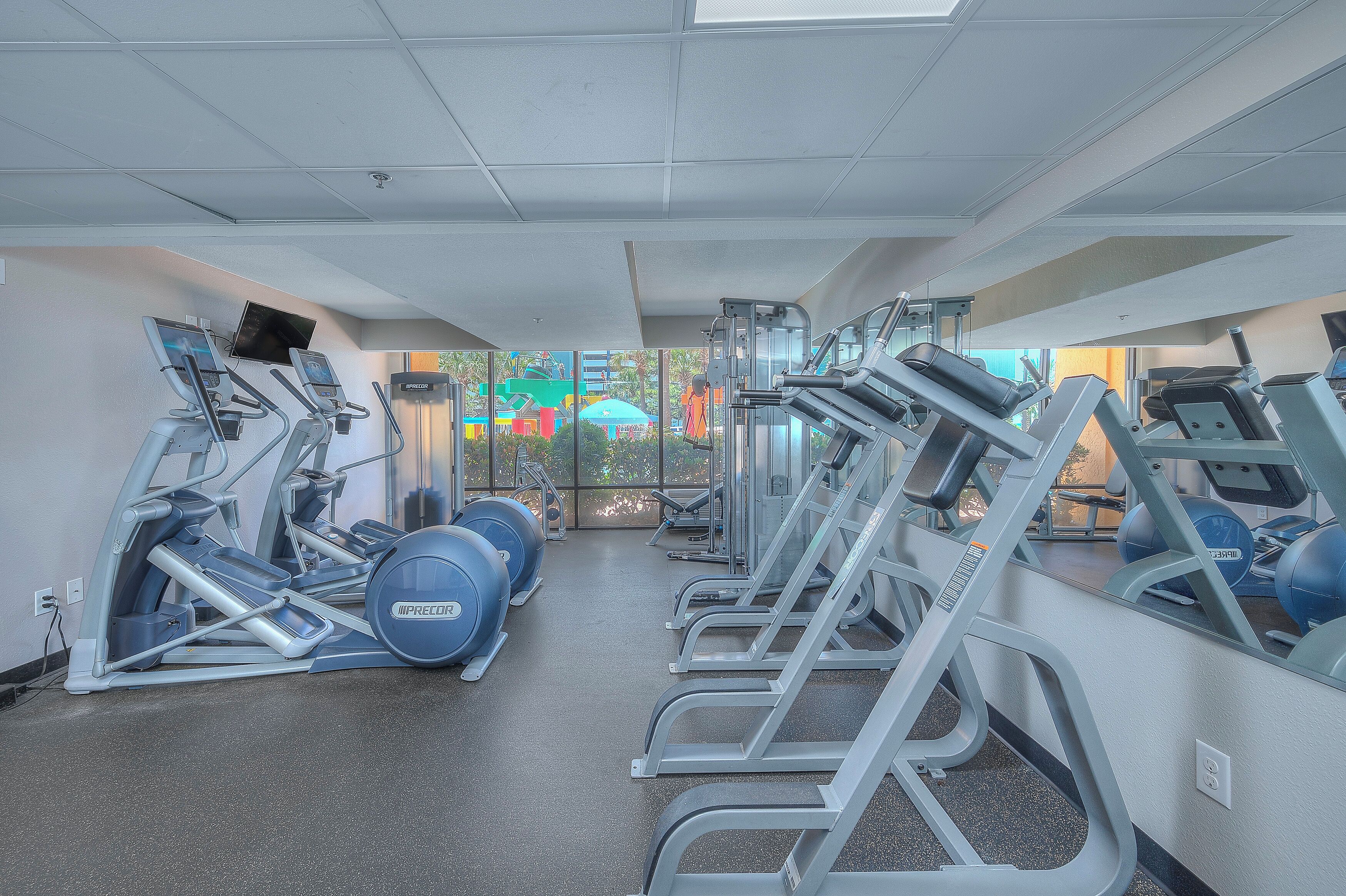 A gym with various exercise equipment, including treadmills and weight machines.
