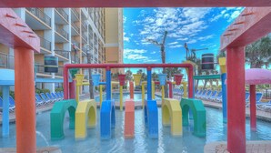 A water play area with colorful structures and a pool with lounge chairs in the background. - Units at Caravelle Resort by Elliott Beach Rentals (Myrtle Beach)