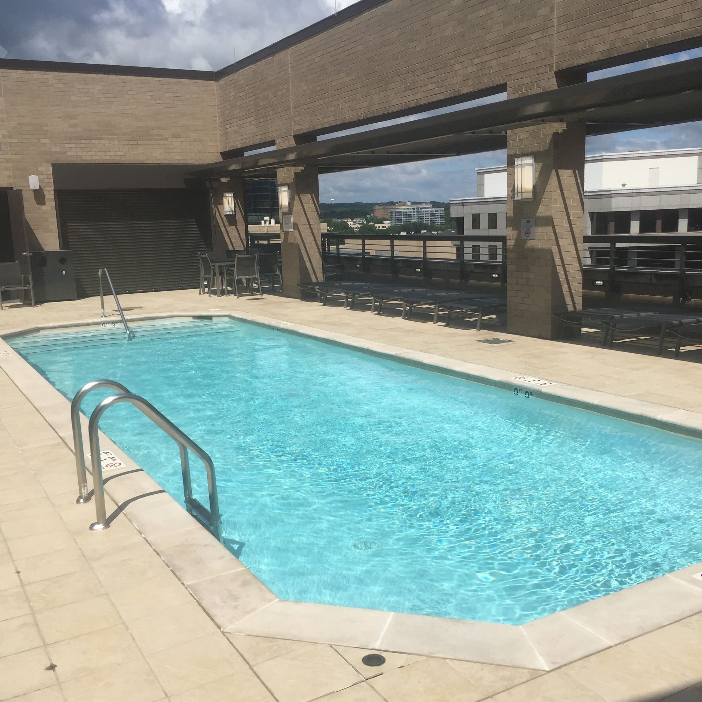 Une piscine rectangulaire à l’eau d’un bleu limpide, entourée d’une terrasse carrelée.