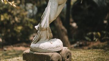 A statue of a woman in a garden setting.