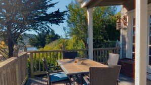 Een houten terras met een tafel en stoelen, met uitzicht op een prachtig landschap.