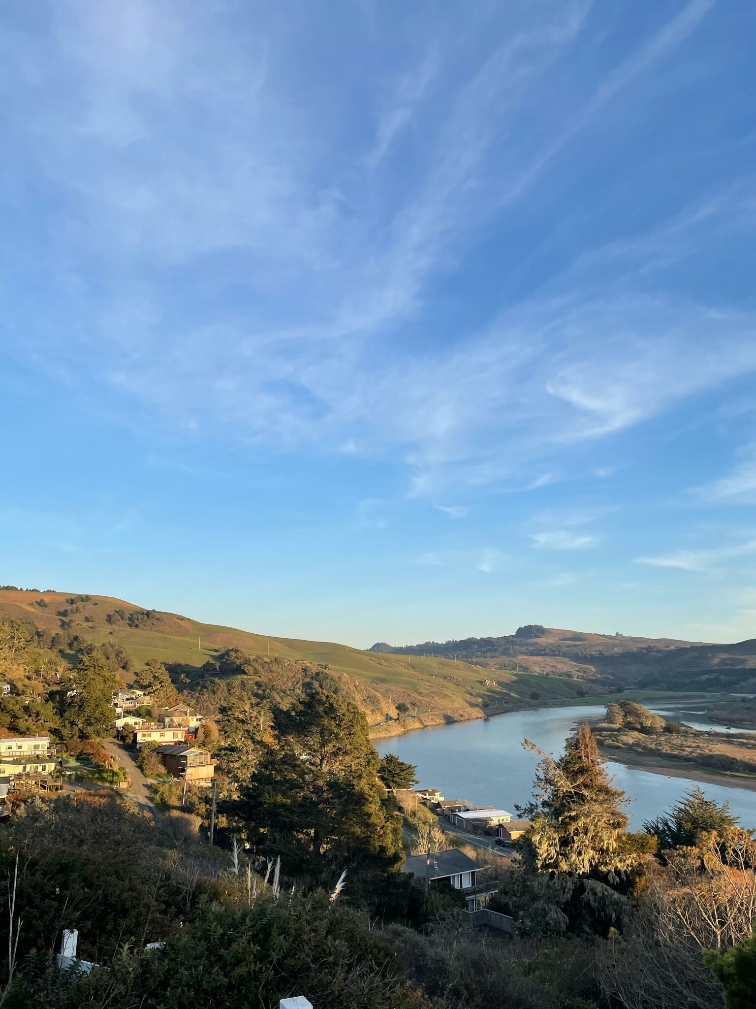 Una vista panorámica de un valle fluvial con casas y árboles.