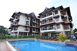A multi-story hotel with balconies, a swimming pool, and lounge chairs. - Steung Siemreap Residences & Apartment (Siem Reap)
