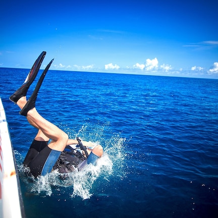 A person diving into the ocean from a boat.
