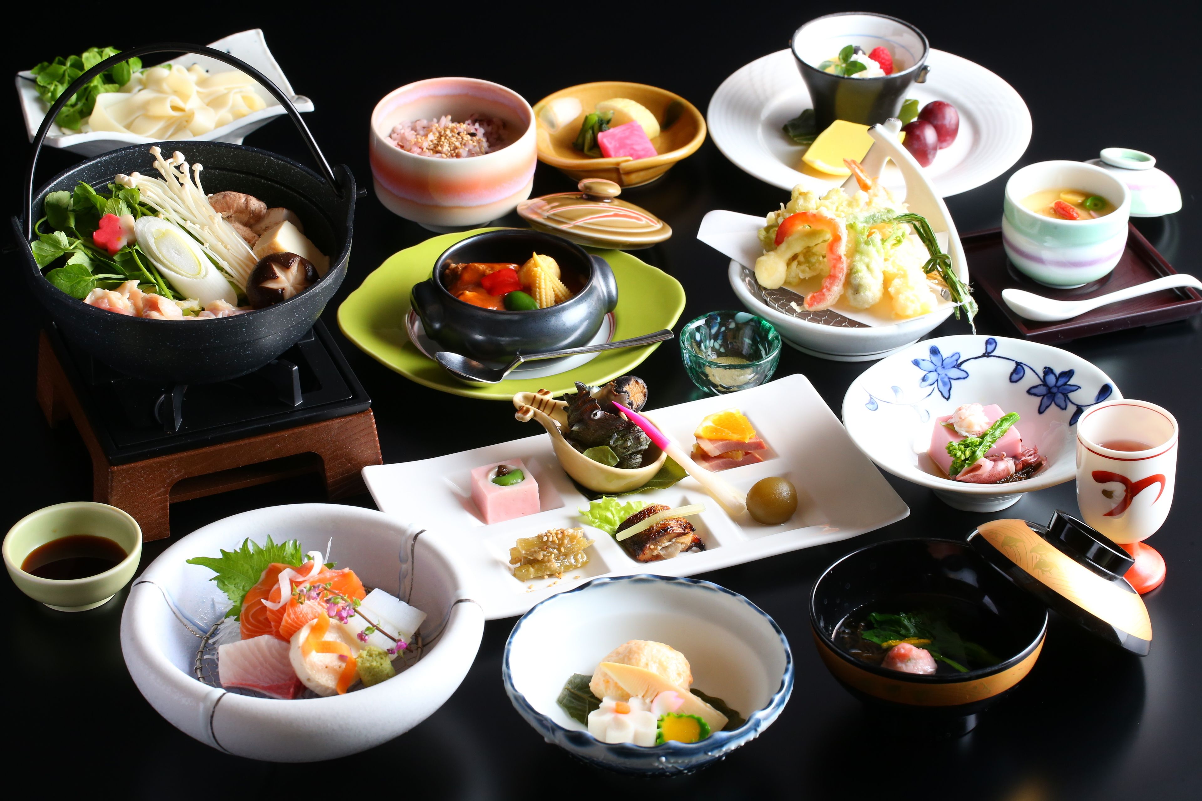 Une variété de plats japonais, notamment des sushis et des sashimis, disposés sur une table.