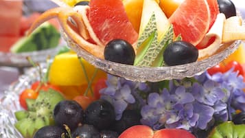 A multi-tiered fruit display with various fruits and berries.