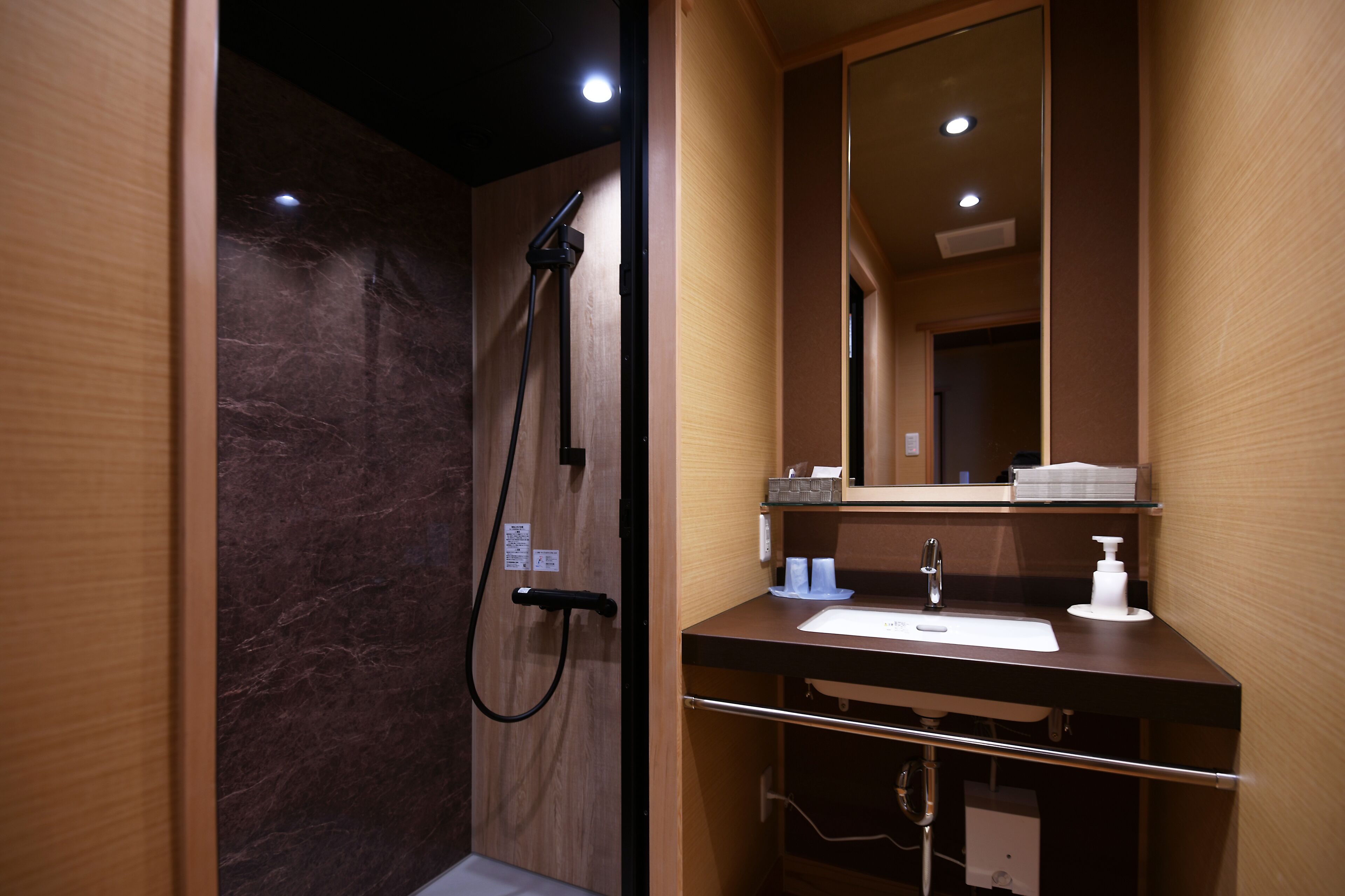 Un baño moderno con ducha, lavabo y espejo.