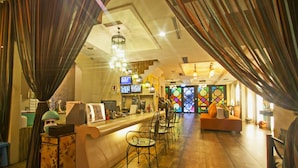 A bar area with a counter, multiple chairs, and a seating area with a sofa. - Moroccan Holiday Suite (Hualien City)