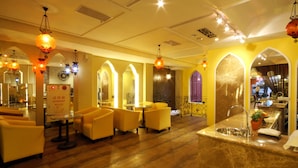 A hotel lobby with yellow sofas, a reception desk, and a bar area. - Moroccan Holiday Suite (Hualien City)