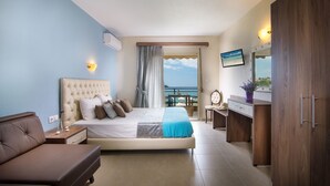 A hotel room with a bed, a desk, a chair, a sofa, and a balcony with a view. - Castro Deluxe (Sithonia)