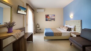 A hotel room with a bed, bedside table, nightstand, and a desk with a chair. - Castro Deluxe (Sithonia)