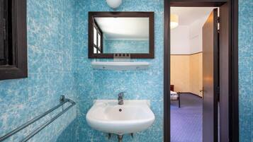 A bathroom with a white sink, a mirror, and a towel rack.