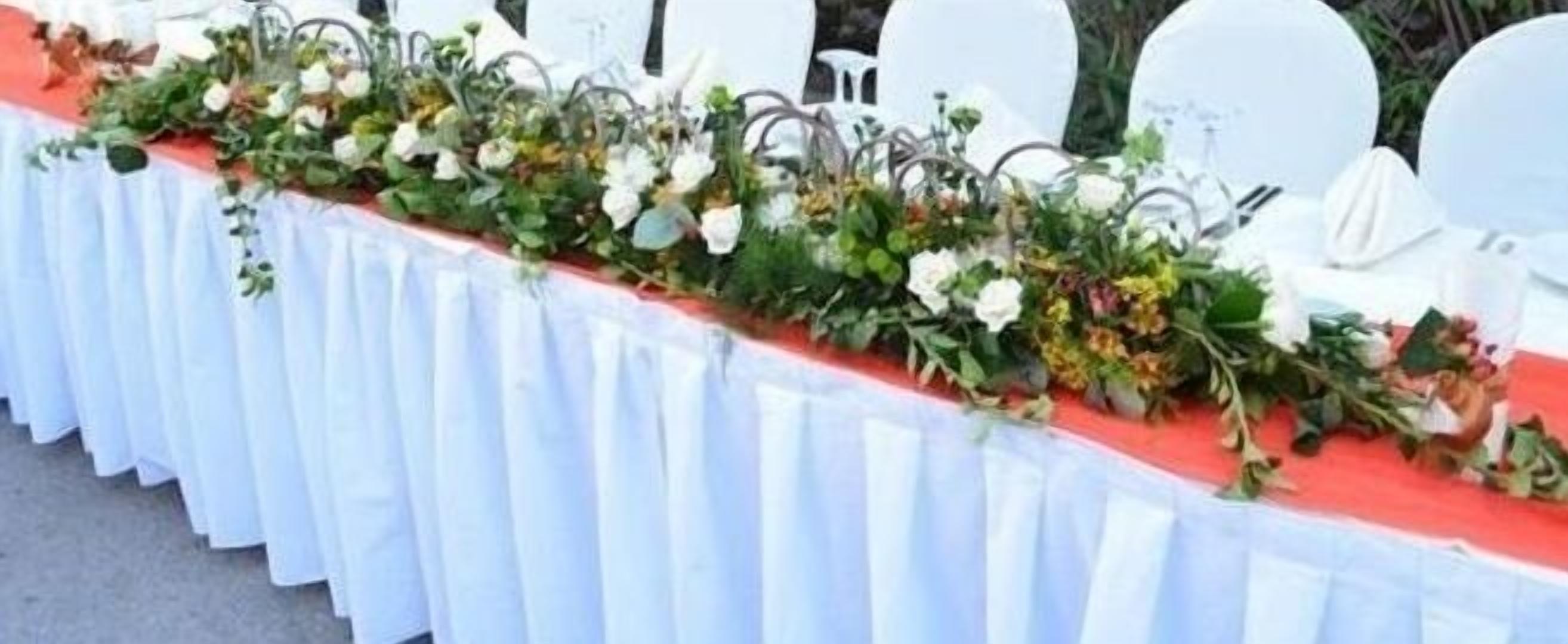 A table with a white tablecloth and a floral arrangement.