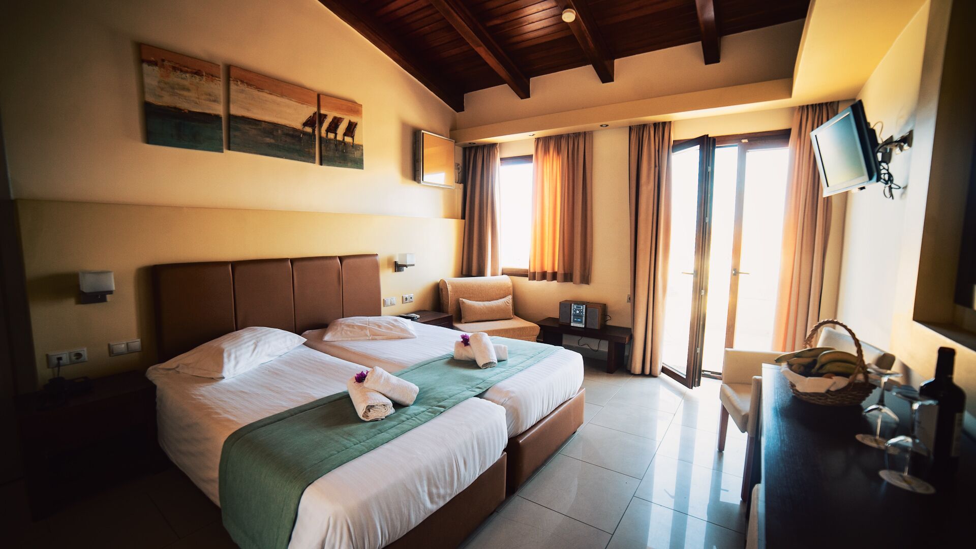 Une chambre d’hôtel avec un grand lit, un bureau avec un ordinateur et un téléviseur fixé au mur.