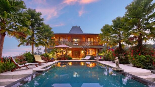A large house with a swimming pool, surrounded by palm trees and red flowers. - Ti Amo Bali (Penebel)