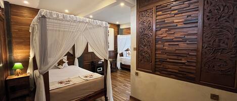 Una cama con dosel y columnas, paneles de madera en las paredes y una mesita de noche con lámpara.