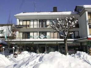Ein mehrstöckiges Gebäude, im Erdgeschoss befindet sich ein Café namens 'Cafe Heck'.
