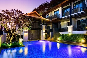 A modern hotel with a swimming pool, outdoor lighting, and a multi-story building with balconies. - Yotaka Bangkok Hotel (Bangkok)