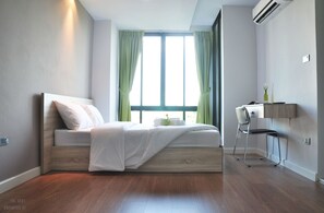 A modern bedroom with a bed, a desk, and a chair. - The Vert Apartment (Bangkok)