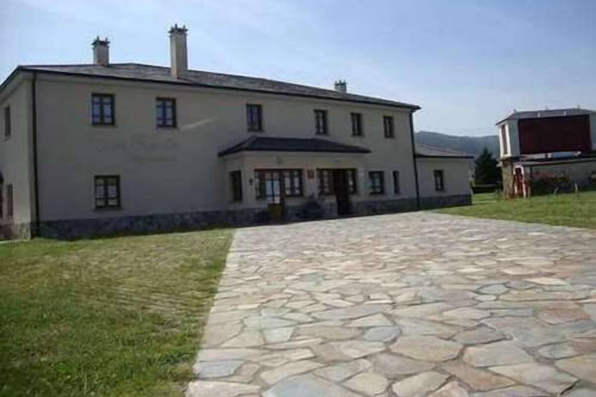 A large, single-story building with a stone-paved entrance and a small porch.