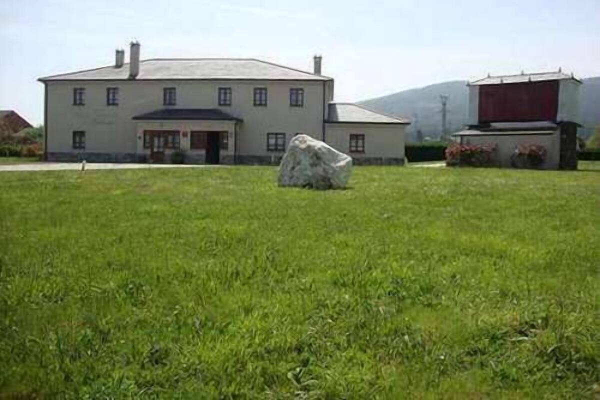 A large, single-story building with a symmetrical facade, a central entrance, and a small porch area.